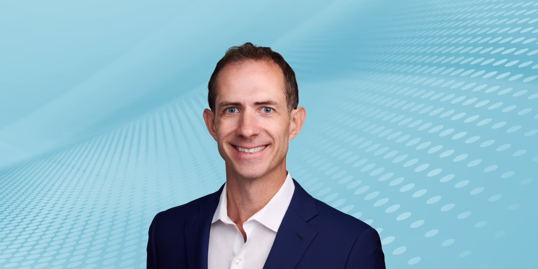 A photo of Veris Advisor Tim Kingsbury, a smiling white man wearing a white shirt and blue suit jacket.