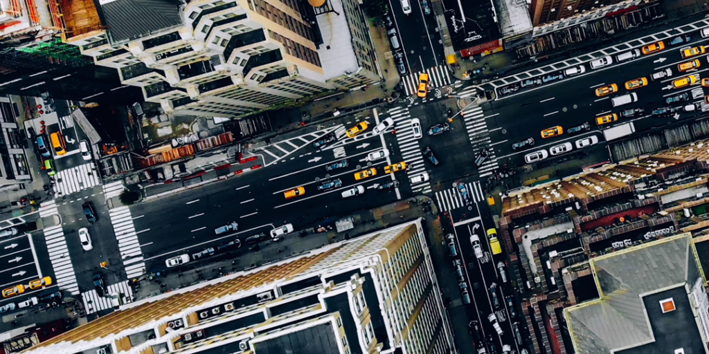 Aerial view of an urban landscape, its streets and city blocks forming a dense grid.